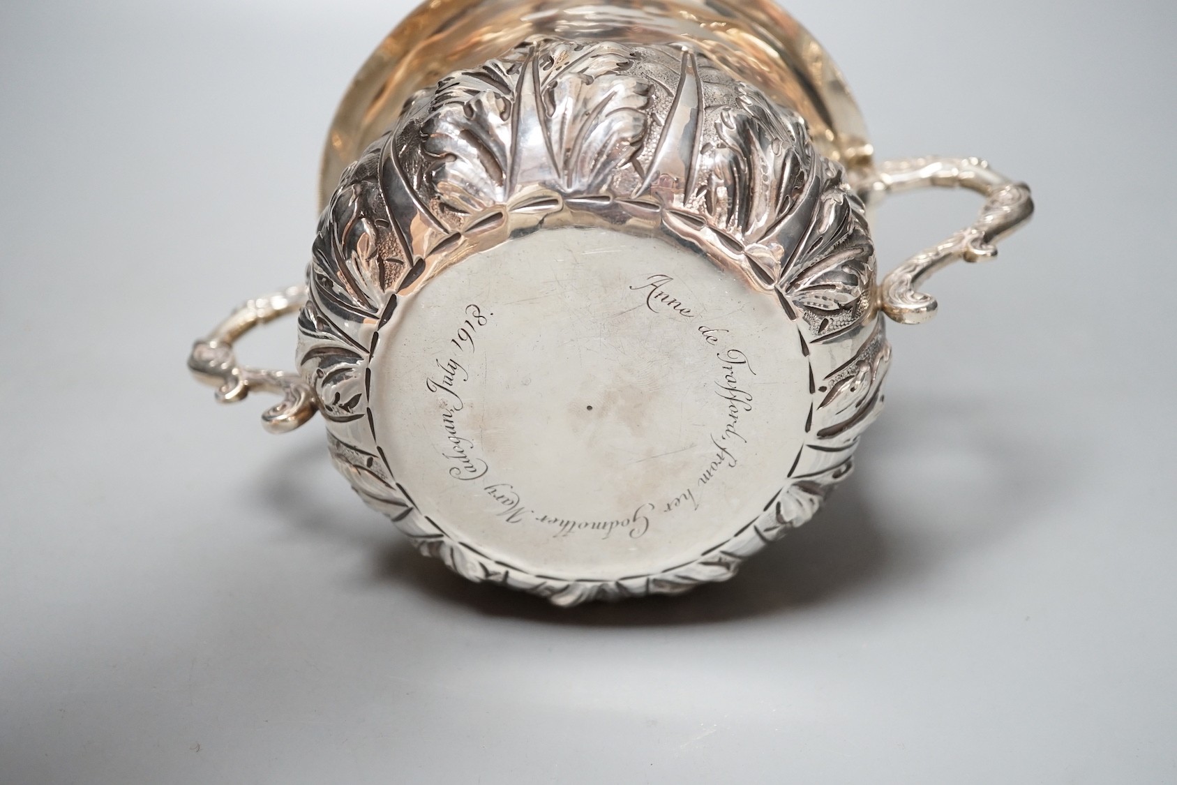 A George V embossed Brittania standard silver two handled presentation bowl and cover, Carrington & Co, London, 1916, diameter 18.6cm over handles, 18.5oz.